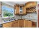 Bright kitchen with granite countertops, wood cabinets, and a window overlooking the backyard at 1619 E Nome St, Tampa, FL 33604