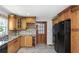 Kitchen features granite countertops, wood cabinets, black appliances, and access to backyard at 1619 E Nome St, Tampa, FL 33604