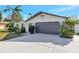 Modern home exterior with gray garage door and white walls at 1660 83Rd N Ave, St Petersburg, FL 33702