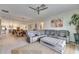 Living room with sectional sofa and large TV, view into dining and kitchen area at 17219 Scuba Crest St, Wimauma, FL 33598