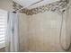 Beige tile shower with mosaic accent tile and handheld shower head at 1742 Bayshore Blvd, Dunedin, FL 34698