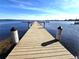 Long wooden dock extending into calm lake water at 2607 Grand Lakeside Dr, Palm Harbor, FL 34684