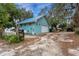 Light teal home with a metal roof and a driveway at 2886 Bay Shore Dr, Safety Harbor, FL 34695