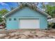 Detached garage with white roll-up door and light teal exterior at 2886 Bay Shore Dr, Safety Harbor, FL 34695