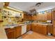 L-shaped kitchen with wood cabinets, a dishwasher, and a wall of kitchen tools at 2886 Bay Shore Dr, Safety Harbor, FL 34695