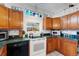 Modern kitchen with wood cabinets, green countertops and white appliances at 2886 Bay Shore Dr, Safety Harbor, FL 34695