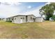 Tan home exterior with carport, shed, and grassy yard at 36900 Grace Ave, Zephyrhills, FL 33542