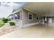 Tan mobile home with carport and landscaping at 36900 Grace Ave, Zephyrhills, FL 33542