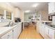 Long kitchen with white cabinets and view into dining area at 36900 Grace Ave, Zephyrhills, FL 33542