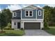 Two-story home with blue siding, dark gray garage door, and landscaping at 37268 Sagemoor Dr, Zephyrhills, FL 33541