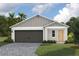 Two-car garage and front entrance of a charming new home with a landscaped yard at 37287 Sagemoor Dr, Zephyrhills, FL 33541