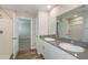 Double vanity bathroom with a large mirror and access to bedroom at 37306 Sagemoor Dr, Zephyrhills, FL 33541