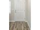 Modern entryway with wood-look tile floor and white door at 37306 Sagemoor Dr, Zephyrhills, FL 33541