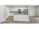 Modern kitchen with white cabinets, island and stainless steel appliances at 37306 Sagemoor Dr, Zephyrhills, FL 33541