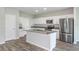 Modern kitchen with white cabinets, island and stainless steel appliances at 37306 Sagemoor Dr, Zephyrhills, FL 33541