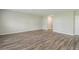 Spacious living room with wood-look floors and access to hallway at 37306 Sagemoor Dr, Zephyrhills, FL 33541