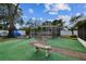 Landscaped backyard with a large tree, a brick pathway, and a pool enclosure at 4360 82Nd N Ave, Pinellas Park, FL 33781