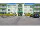 Light green building exterior with parking and entrance at 464 N Paula Dr # 220, Dunedin, FL 34698