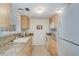 Efficient kitchen with granite countertops and light wood cabinets at 464 N Paula Dr # 220, Dunedin, FL 34698