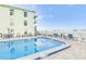 Community pool with plenty of lounge chairs and patio furniture at 464 N Paula Dr # 220, Dunedin, FL 34698