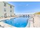 Refreshing community pool area with patio furniture and waterfront views at 464 N Paula Dr # 220, Dunedin, FL 34698
