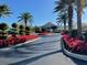 Landscaped clubhouse entrance with palm trees and flowers at 6303 Green Oak Cir, Bradenton, FL 34203
