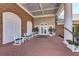 Brick clubhouse porch with white chairs and plants at 6303 Green Oak Cir, Bradenton, FL 34203