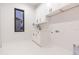 Bright laundry room with white cabinets and a window at 716 S Lois Ave, Tampa, FL 33609