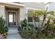 Front entrance with dark gray door, stone accents, and lush landscaping at 8442 Lagerfeld Dr, Land O Lakes, FL 34637