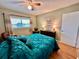 Well-lit bedroom with teal bedding, wood floors, and ceiling fan at 2043 Denmark St # 57, Clearwater, FL 33763