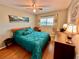 Spacious bedroom with teal bedding, wood floors, and ceiling fan at 2043 Denmark St # 57, Clearwater, FL 33763
