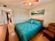 Bright bedroom with teal bedding, wood floors, and access to hallway at 2043 Denmark St # 57, Clearwater, FL 33763