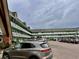 Exterior view of a light green building with ample parking at 2043 Denmark St # 57, Clearwater, FL 33763