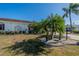 Landscaped front yard with palm trees and a circular driveway at 1207 Bluewater Dr, Sun City Center, FL 33573