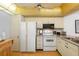 Galley kitchen with white appliances and granite countertops at 12200 Vonn Rd # 1106, Largo, FL 33774