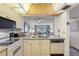 Kitchen with view into living room, white appliances, and granite countertops at 12200 Vonn Rd # 1106, Largo, FL 33774
