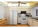 Galley kitchen with white appliances and granite countertops at 12200 Vonn Rd # 1106, Largo, FL 33774