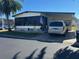 Single-wide manufactured home with carport and mature landscaping at 12501 Ulmerton Rd # 140, Largo, FL 33774