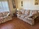 Living room with floral sofas and wood flooring at 12501 Ulmerton Rd # 140, Largo, FL 33774