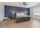 Main bedroom with a dark blue accent wall and wood flooring at 13513 White Sapphire Rd, Riverview, FL 33579