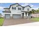 Two-story house with gray siding, stone accents, and a three-car garage at 13513 White Sapphire Rd, Riverview, FL 33579