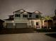Two-story house with lights, gray siding, and a three-car garage at 13513 White Sapphire Rd, Riverview, FL 33579