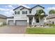 Two-story house with gray siding, stone accents, and a three-car garage at 13513 White Sapphire Rd, Riverview, FL 33579