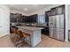 Modern kitchen with dark cabinetry, granite counters, and stainless steel appliances at 13513 White Sapphire Rd, Riverview, FL 33579