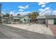 A light green house with a small front yard, detached garage, and palm trees at 137 91St Ave, Treasure Island, FL 33706