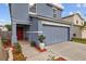 Two-story house with gray siding, red door, landscaping, and a two-car garage at 17347 Mint Leaf Ln, Land O Lakes, FL 34638