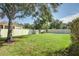 Spacious backyard with grassy lawn, mature trees, and privacy fence at 17409 New Cross Cir, Lithia, FL 33547