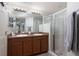 Bathroom with double vanity, large mirror, and shower at 17409 New Cross Cir, Lithia, FL 33547