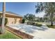 Two-car garage with a long driveway and mature trees at 17409 New Cross Cir, Lithia, FL 33547