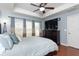 Main bedroom with hardwood floors, large TV, and ceiling fan at 17409 New Cross Cir, Lithia, FL 33547